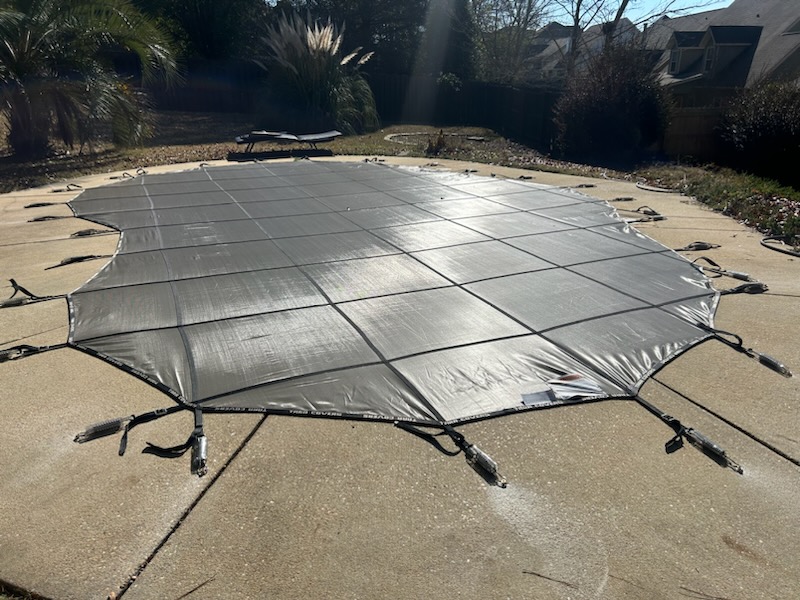 Silver mesh pool safety cover professionally installed &mdash; Elkins residence, Auburn AL